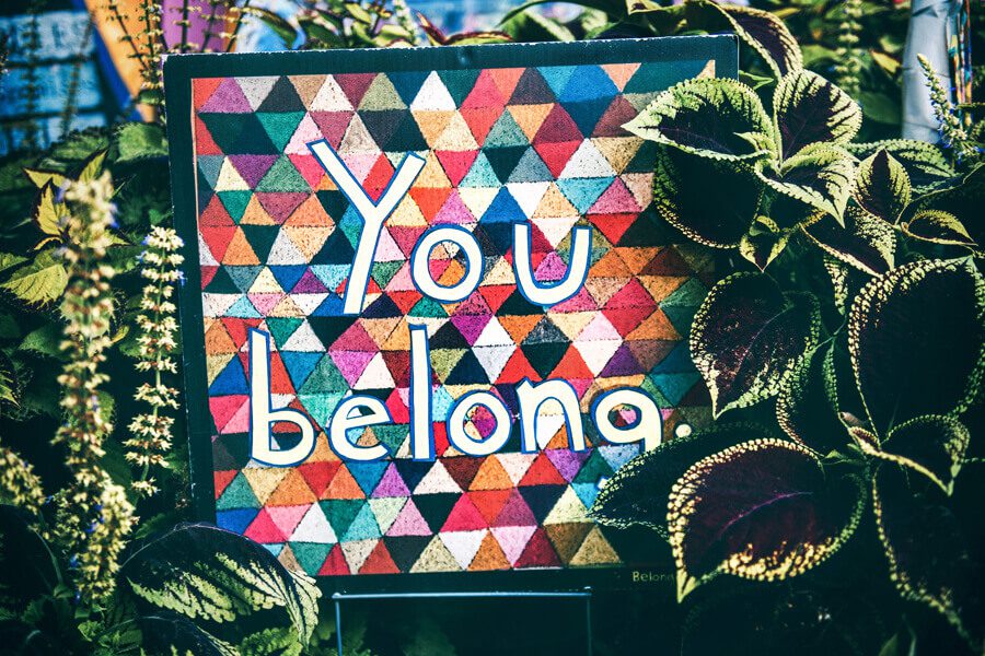 Colorful mural with the words 'You belong' surrounded by plants.